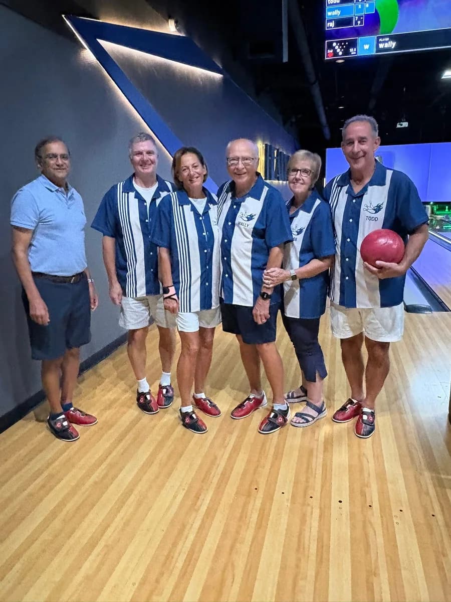 Six WildBlue residents smiling together at a bowling alley